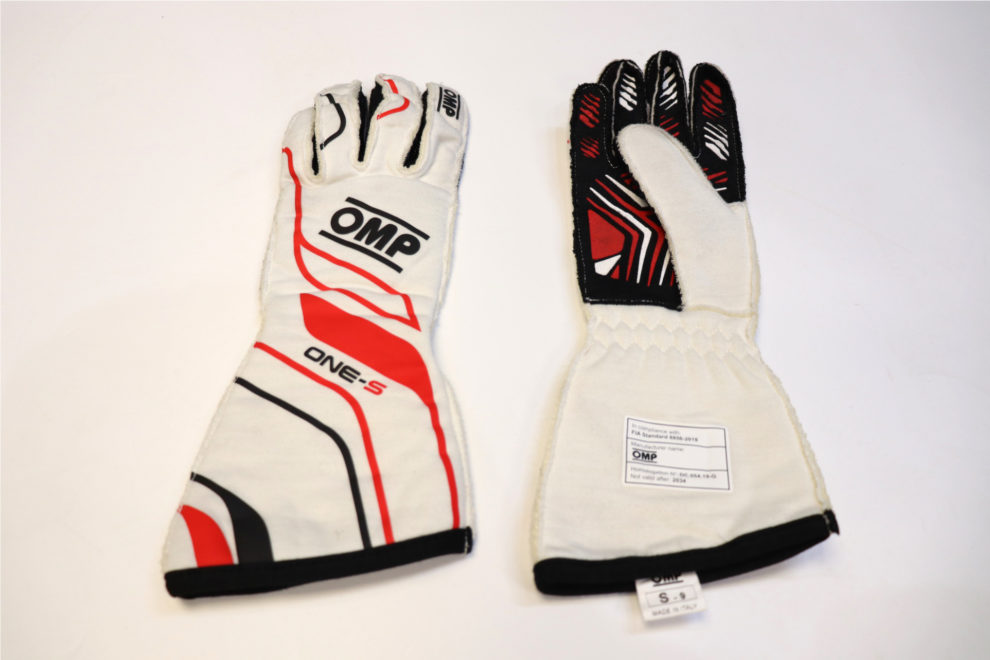 A pair of white OMP One S racing gloves with red and black graphics, one showing the back and one the palm