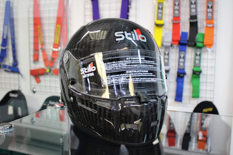 A black Stilo carbon full face helmet on a stand in the GSM Performance showroom