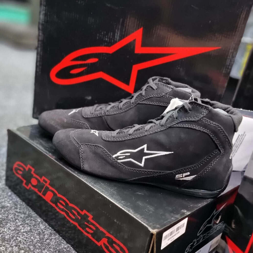 Black Alpinestars SP V2 race boots with the white Alpinestars star logo on a black Alpinestars box