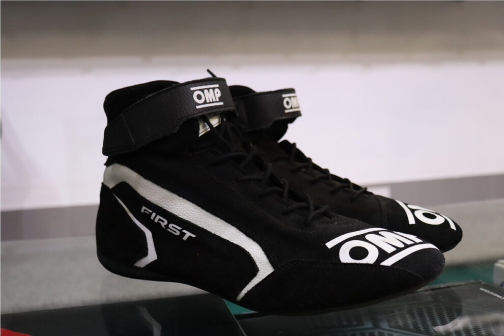 Close up of a black OMP First race boot with white trim and the word First on the side