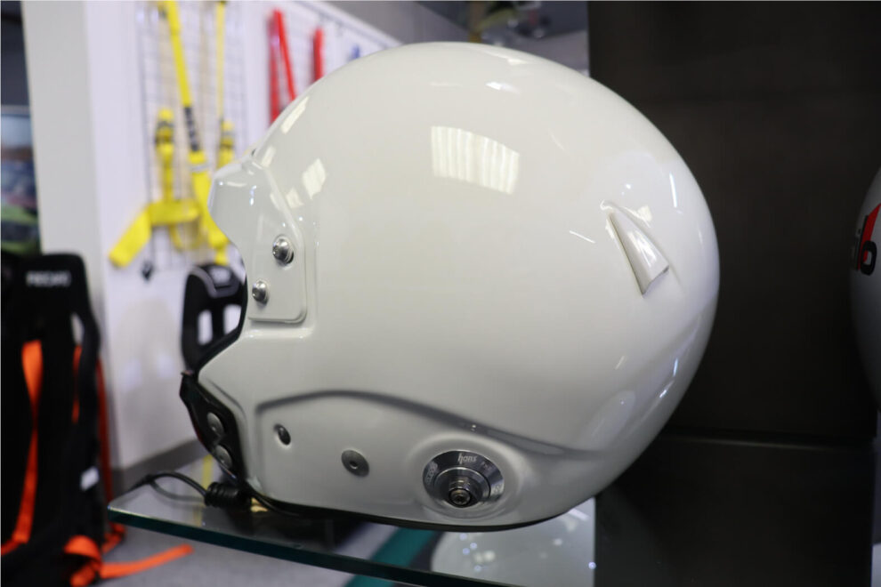 Side view of a white Sparco open face helmet showing the HANS post and intercom lead