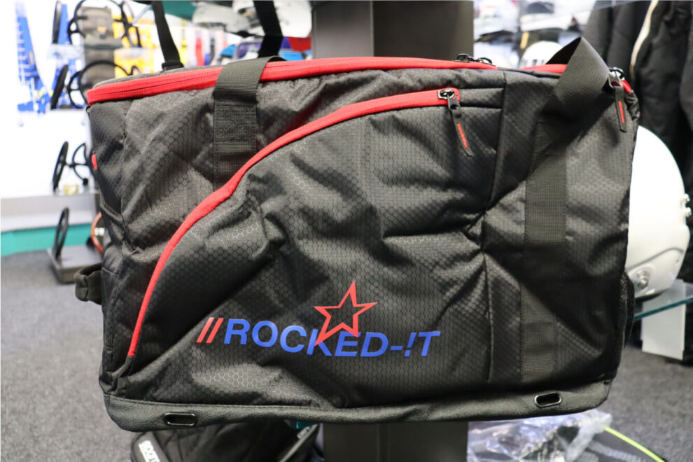 Black Rocked-IT Motorsport Kit Bag with red trim and a blue Rocked-IT logo on the showroom floor