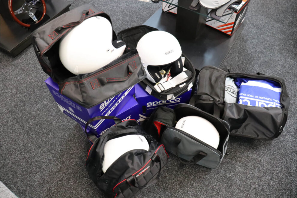 Helmet bags opened on the showroom floor with white open face helmets packed inside