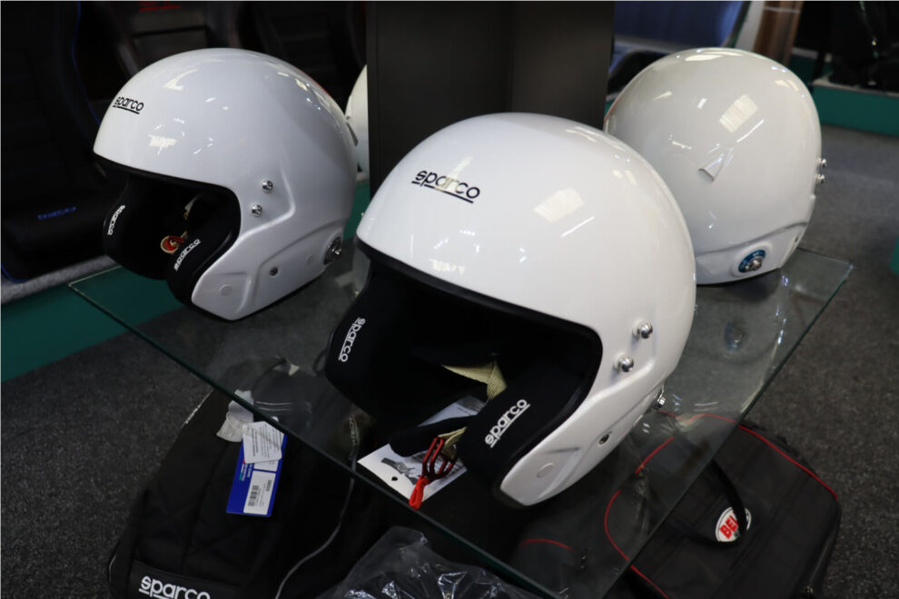 White Sparco open face helmets on a glass shelf in the GSM Performance showroom