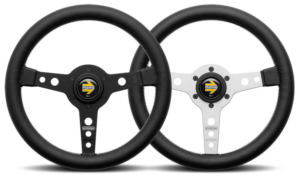 Two MOMO Prototipo 320mm steering wheels side by side, one with black spokes and one with silver spokes