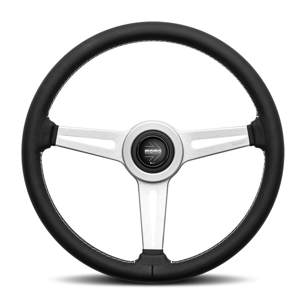The MOMO Retro steering wheel from the front, with three brushed silver spokes, a black leather rim with white stitching and a black MOMO horn button