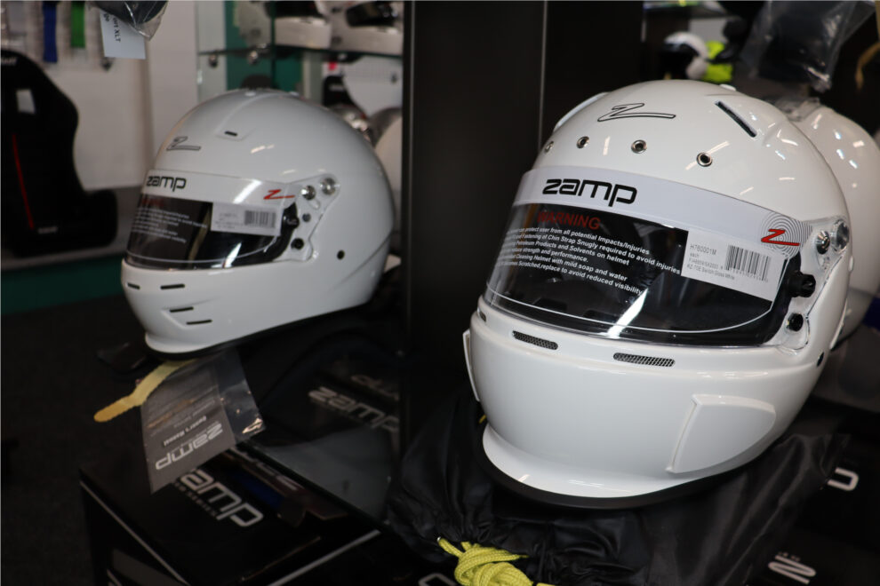 Two white Zamp RZ-70E full face helmets on the display in the GSM Performance showroom, one reflected in a mirror