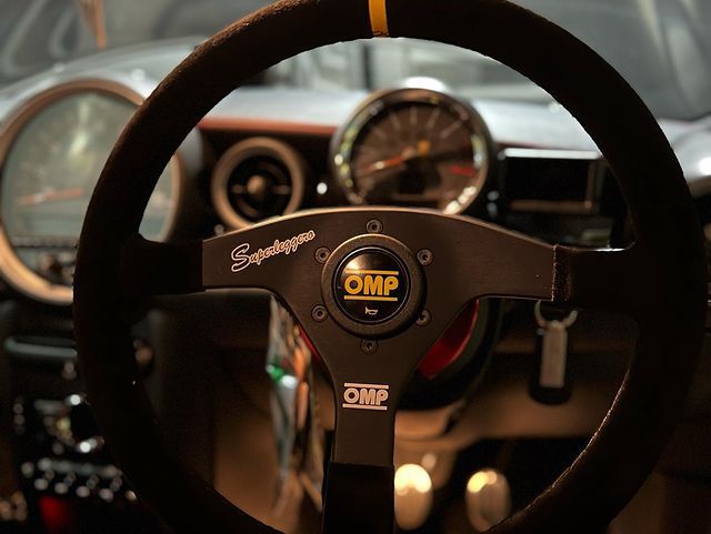 Close view of the OMP Velocita Superleggero suede rim, Superleggero script and OMP horn push in the customer's car