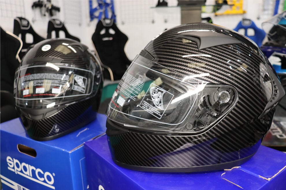 Two Sparco Club X1 Carbon full-face helmets on their blue Sparco boxes in the GSM Performance showroom