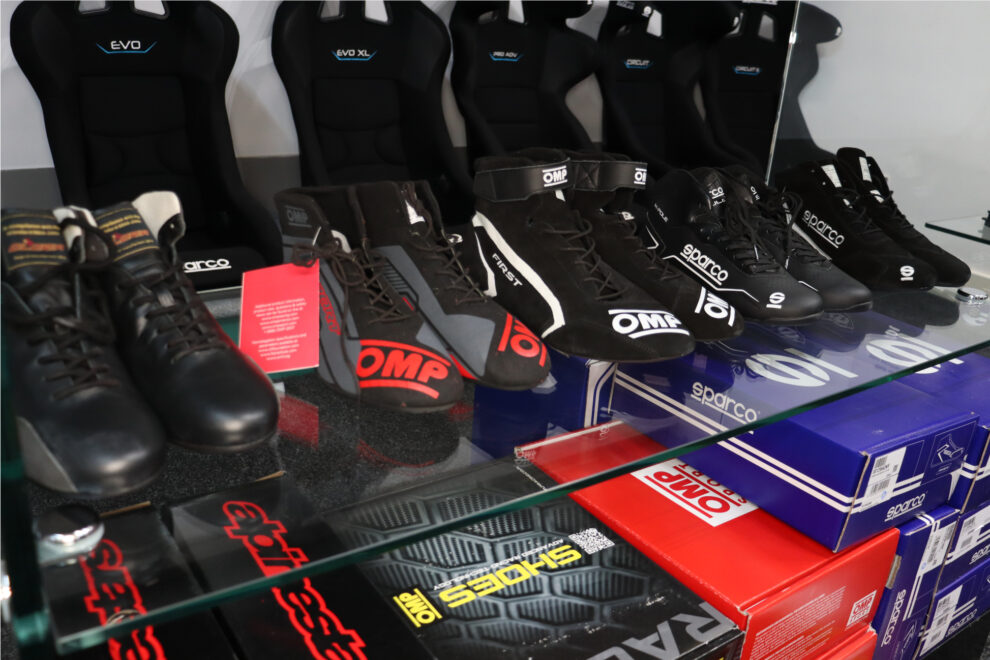 Sparco and OMP race and kart boots on the glass shelves of the GSM Performance showroom