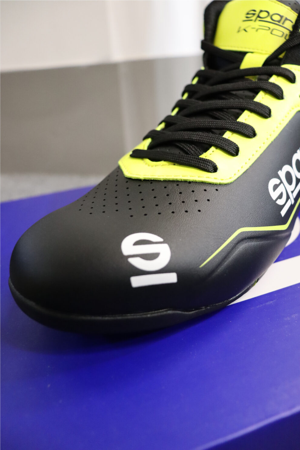 Close-up of the toe of a black and yellow Sparco K-Pole kart boot showing the perforated upper and Sparco logo