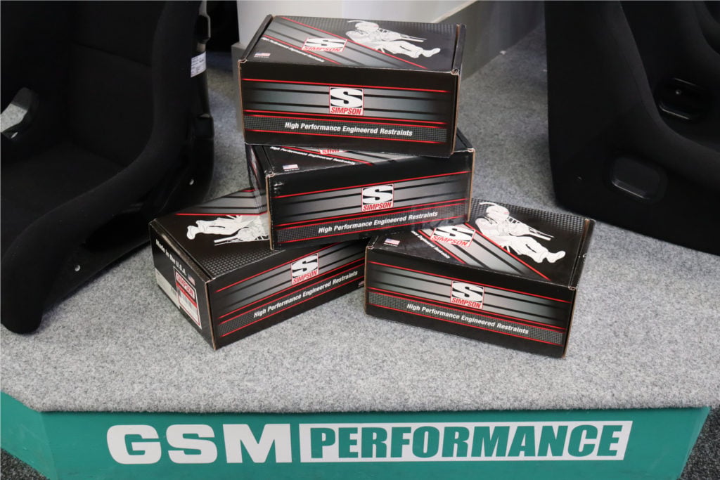 Simpson head and neck restraint boxes stacked on the GSM Performance display stand in the Nottingham showroom