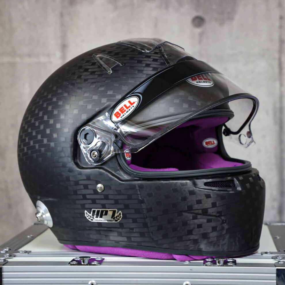A matt carbon Bell HP7 Evo III helmet with a purple interior and the visor raised