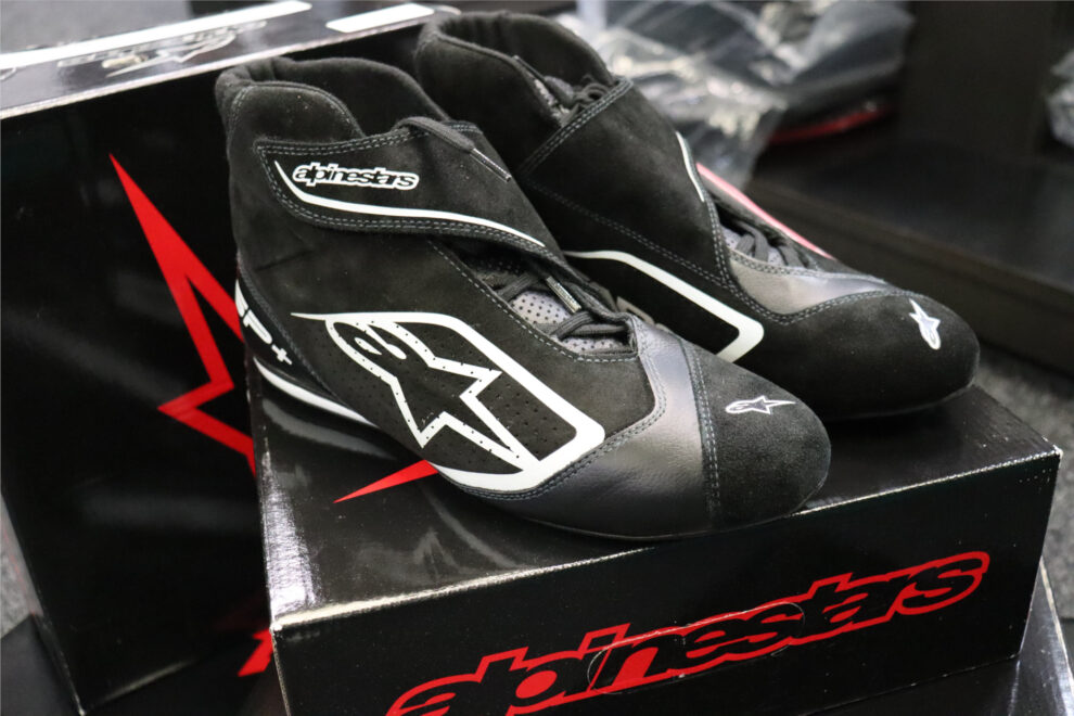A pair of black Alpinestars SP+ race boots on an Alpinestars box