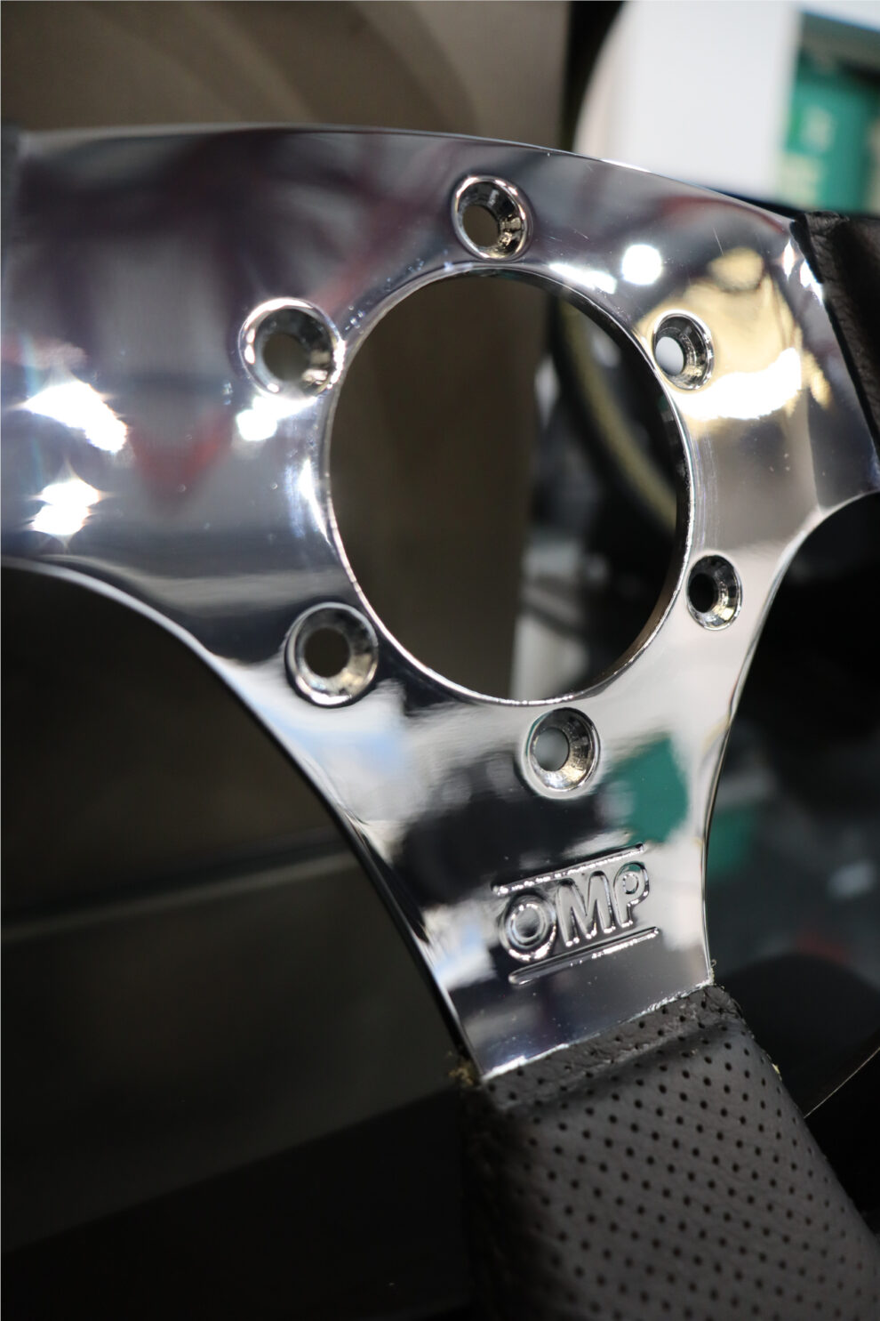 Close up of the polished chrome spoke of an OMP Cromo steering wheel with the OMP logo