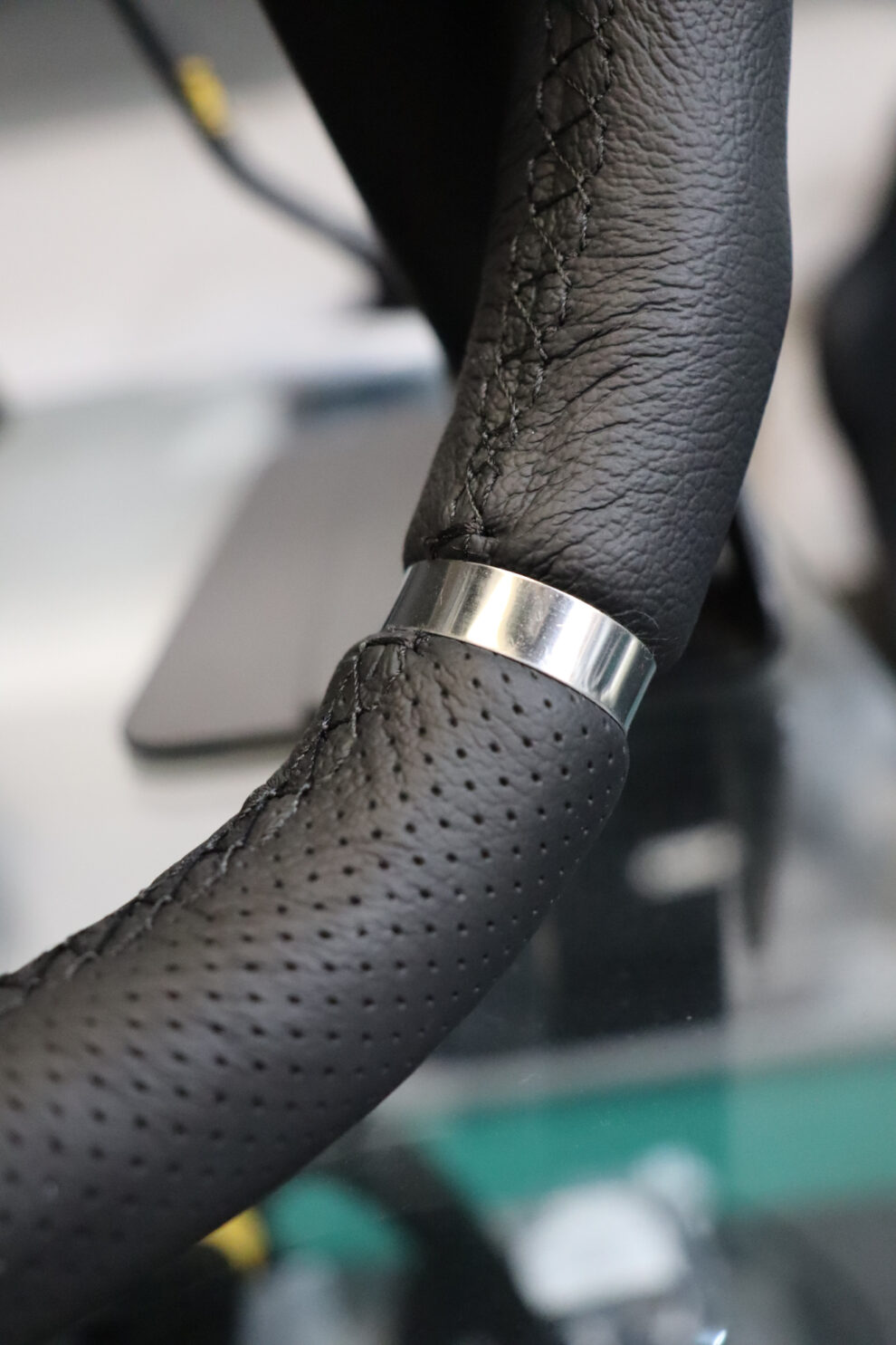 The rim of an OMP Cromo steering wheel showing smooth and perforated leather sections and a chrome band