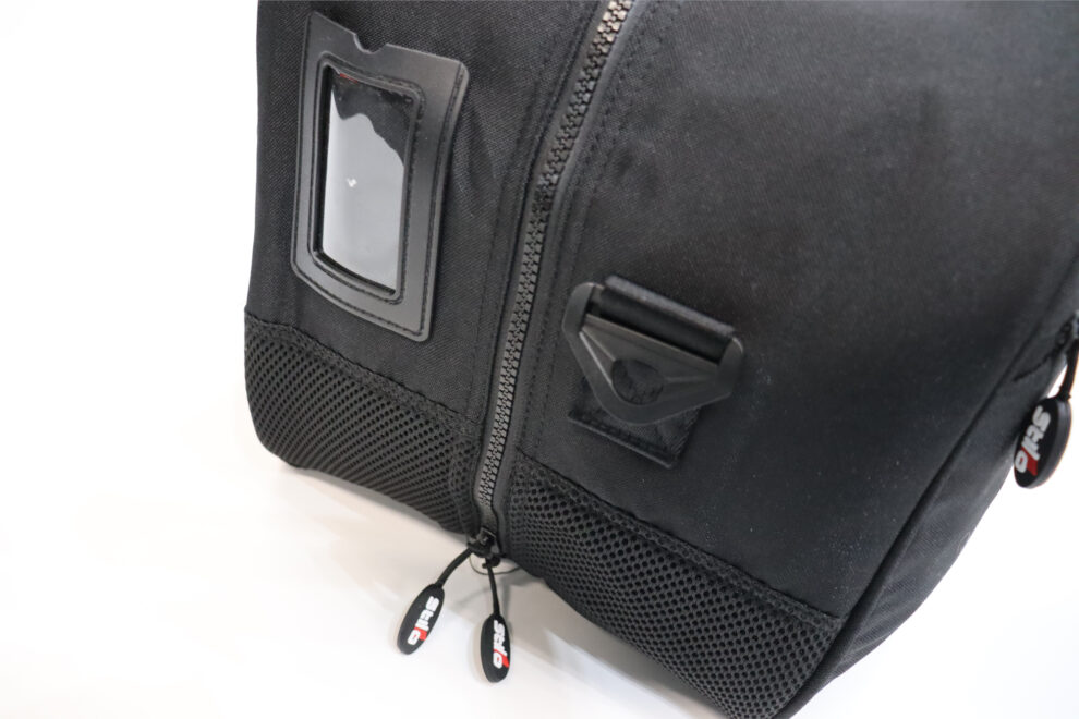 Close view of the base of the black Stilo helmet bag showing the mesh panel, the name card window and the zip pulls