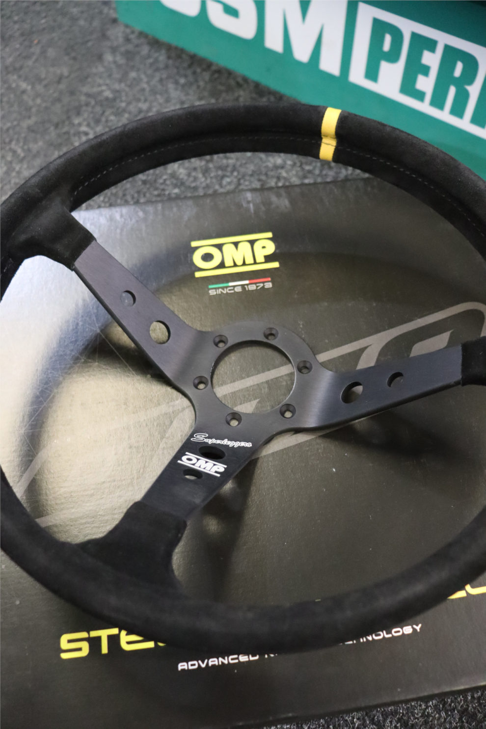 Close view of the OMP Corsica OV Superleggero showing the drilled black spokes, Superleggero script and yellow centre stripe
