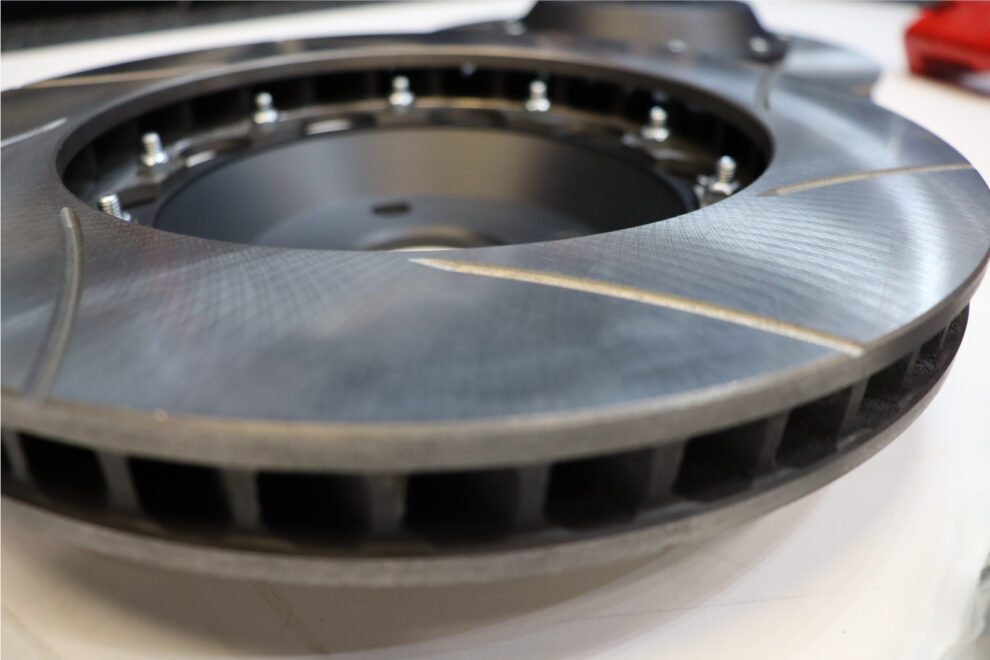 Close view of a Hi Spec two piece brake disc, showing the grooved face, the internal vanes and the bolts holding the aluminium bell