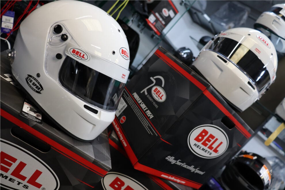 A white Bell GT6 Sport helmet with HANS posts on its box, with more Bell helmets on the shelves behind