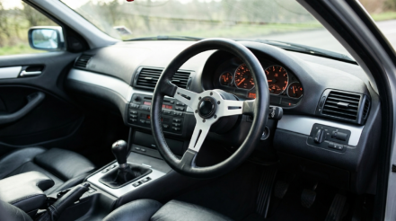 Illustration of a right hand drive BMW E46 interior with a classic three-spoke aftermarket steering wheel fitted