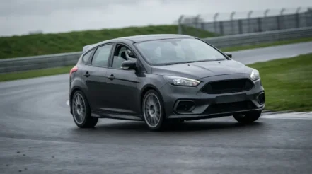 Performance hatchback on track showing suspension travel