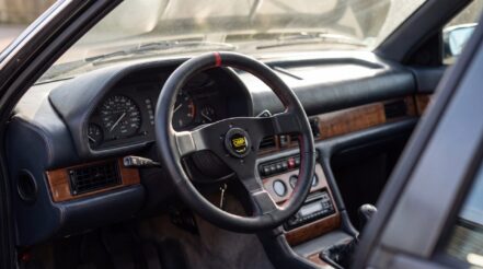 OMP steering wheel fitted to a 1980s Maserati Biturbo, showing the OMP horn button and leather rim with red stitching