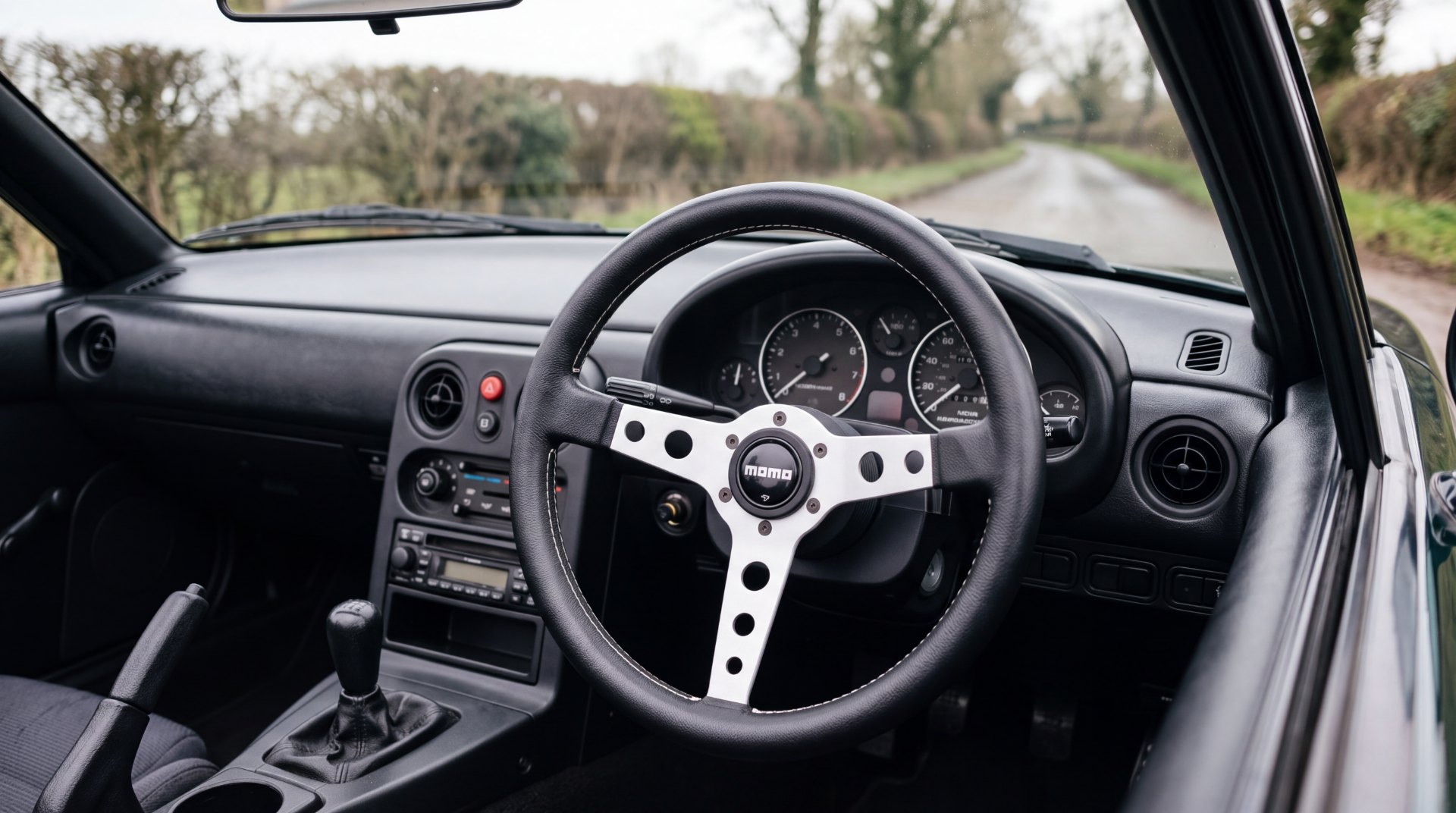 Black leather MOMO steering wheel on a boss kit in the right hand drive cabin of a Mazda MX-5