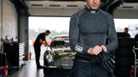 Driver wearing an OMP Tecnica Evo base layer top in a race garage - GSM Performance