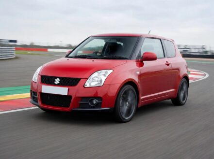 Red Suzuki Swift Sport ZC31S at a racing circuit, fitted with BC Racing coilovers