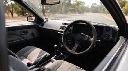 1980s Toyota AE86 Corolla coupe fitted with an aftermarket motorsport steering wheel
