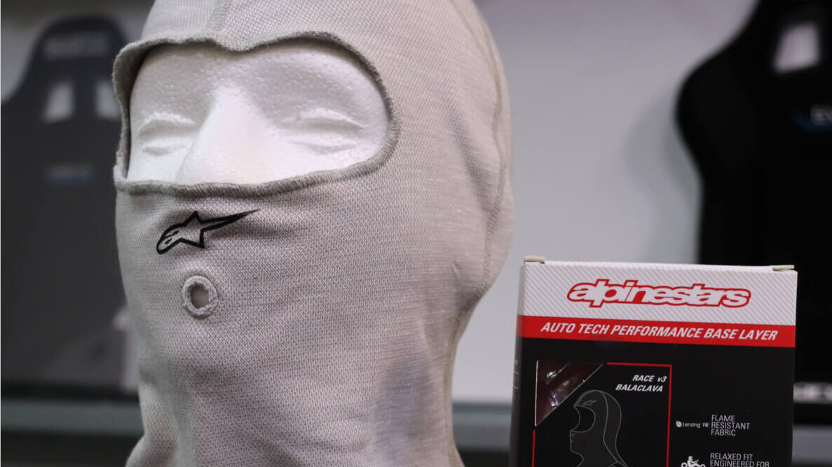 Grey Alpinestars Race V3 balaclava on a display head in the GSM Performance showroom