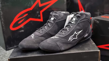 Black Alpinestars SP V2 race boots on their box in the GSM Performance showroom