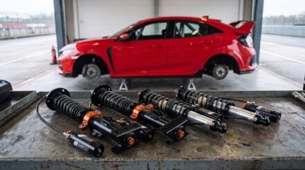 An AST 5200 2-way kit on a pit garage bench with a Honda Civic Type R race car on stands behind