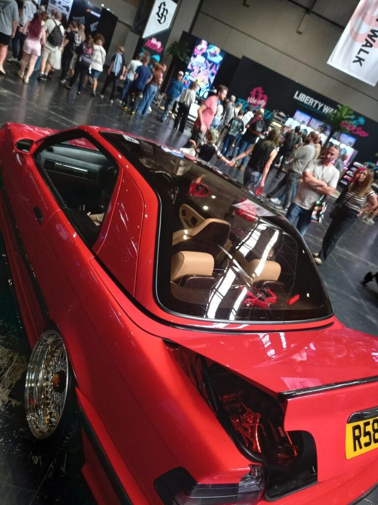 Red BMW E36 coupe with tan leather bucket seats, gold split rim wheels and an air ride install shown in the boot