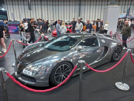 Polished aluminium and carbon Bugatti Veyron on a black stand at the NEC, Gravity Show 2026