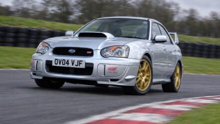 Silver 2004 Subaru Impreza WRX STI, registration OV04 VJF, cornering on a UK race circuit on a track day