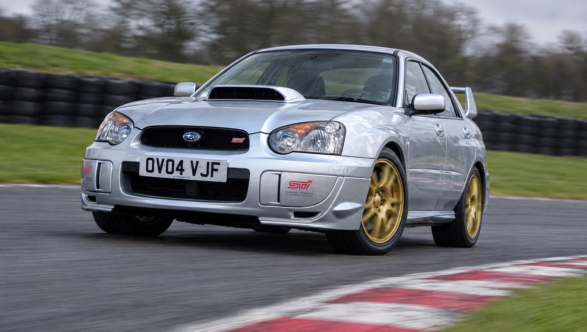 Silver 2004 Subaru Impreza WRX STI, registration OV04 VJF, cornering on a UK race circuit on a track day