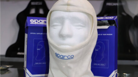 A Sparco fireproof balaclava on a display head in front of its boxes in the GSM Performance showroom
