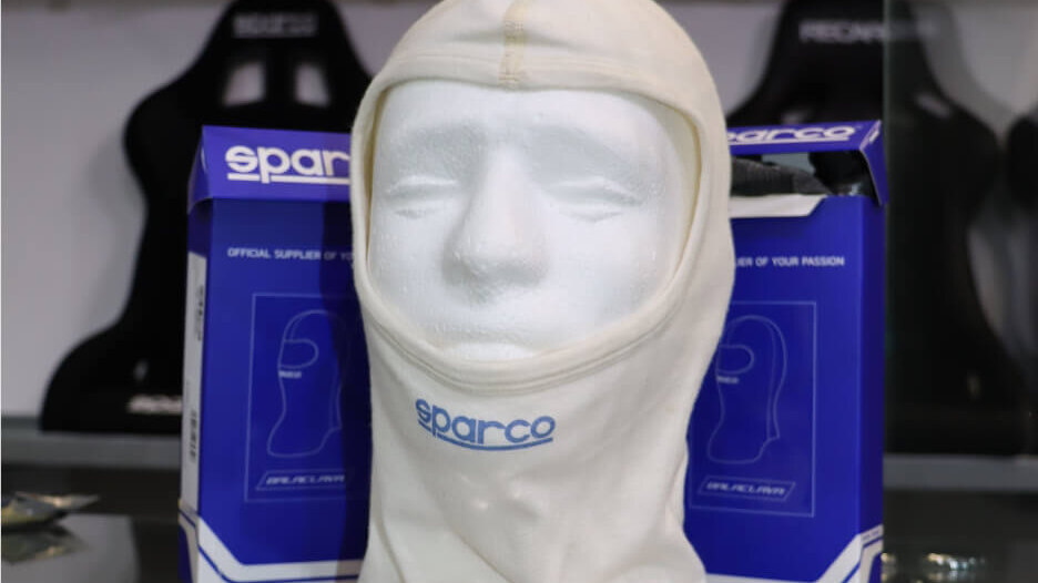 A Sparco fireproof balaclava on a display head in front of its boxes in the GSM Performance showroom