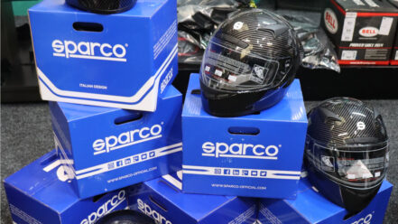 Sparco Club X1 Carbon helmets sitting on stacked blue Sparco boxes in the GSM Performance showroom