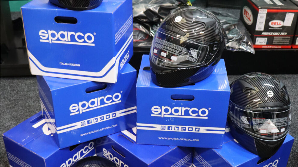 Sparco Club X1 Carbon helmets sitting on stacked blue Sparco boxes in the GSM Performance showroom
