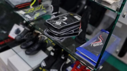 Racing gloves, boots and balaclavas on the glass shelves of the GSM Performance showroom