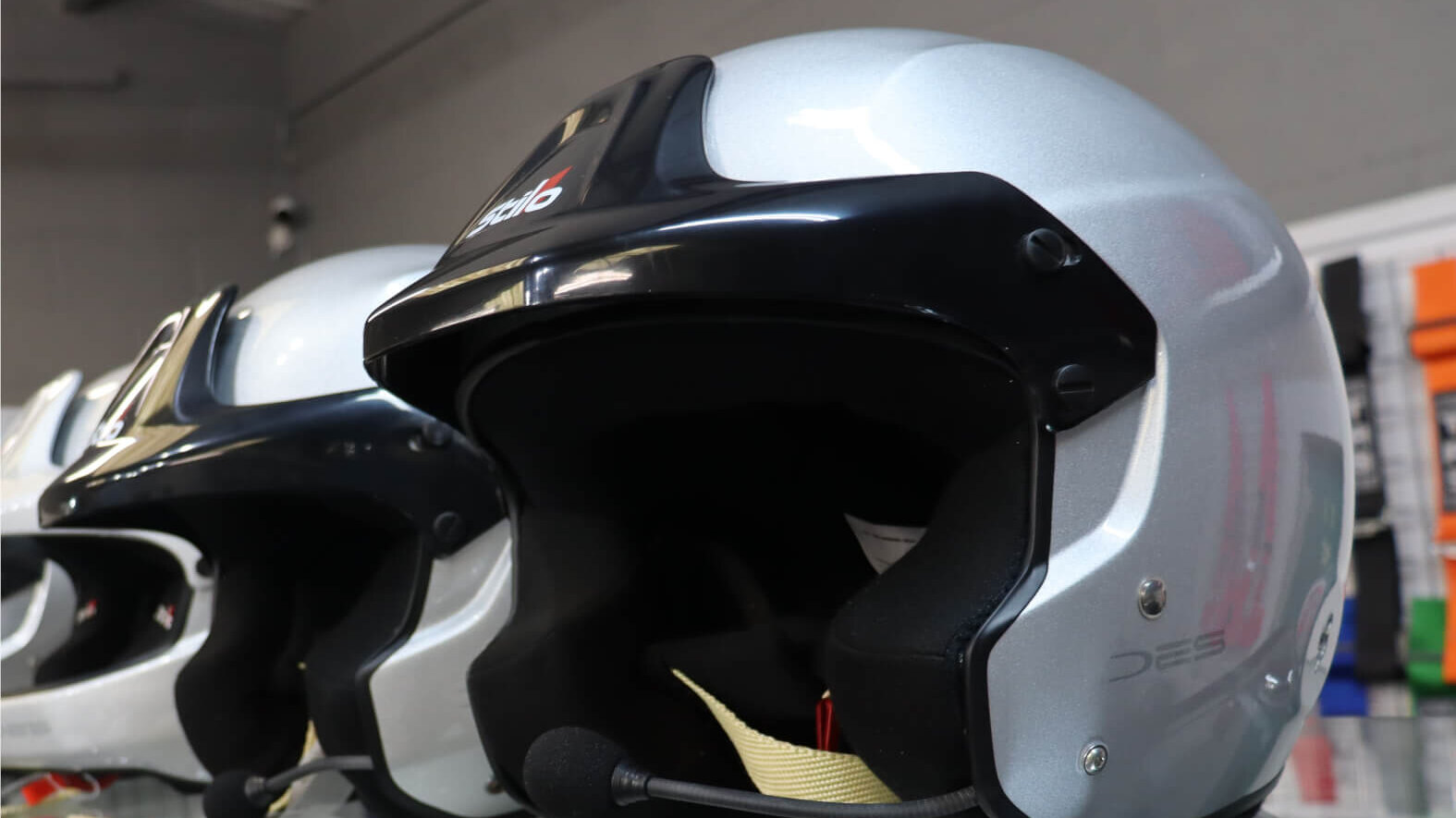 Stilo open face rally helmets on a glass shelf in the GSM Performance showroom