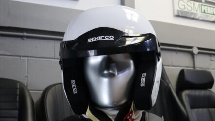 White Sparco Air Pro RJ-3 open face helmet with a black peak, on a mannequin in the GSM Performance showroom