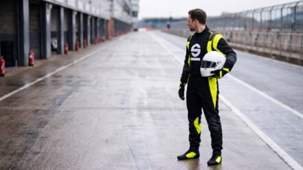 Driver in Sparco Futura Race Suit with Rapid Boots and Futura Gloves standing in a circuit pit lane